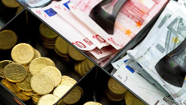 Eine geöffnete Kasse gefüllt mit Euro-Münzen und -Scheinen.