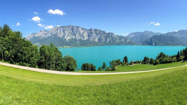 View to lake Attersee with green pasture meadows and Alps mountain range near Nussdorf Salzburg, Austria