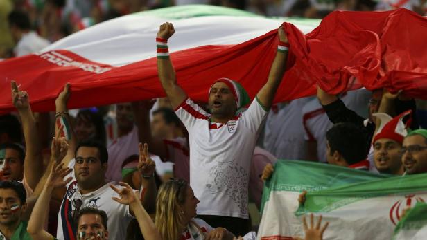 Bei einem Fußballspiel wird die iranische Flagge geschwenkt. Nicht von Frauen.