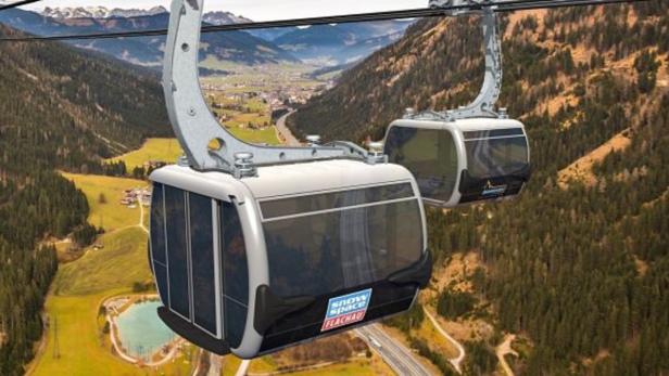 Zwei Gondeln der „Snow Space Flachau“ Seilbahn vor einer Berglandschaft.