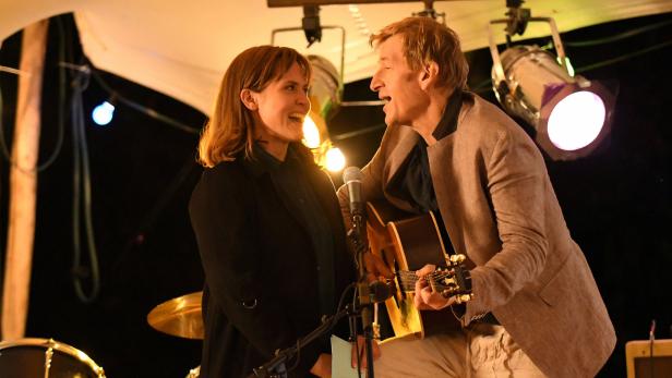 Eine Frau und ein Mann singen gemeinsam, der Mann spielt Gitarre.