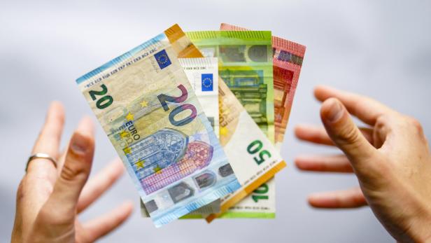 Bargeld in der Hand, darunter 20-, 50- und 10-Euro-Scheine.