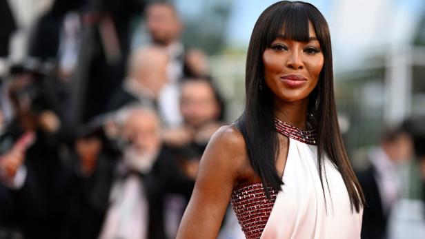 Naomi Campbell in einem weißen Kleid auf dem roten Teppich.