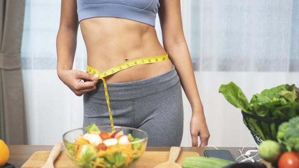 Woman measuring her waist - Stock-Fotografie