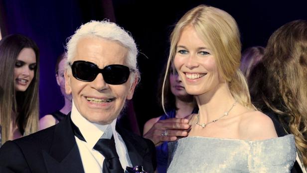 Karl Lagerfeld und Claudia Schiffer posieren lächelnd für ein Foto.