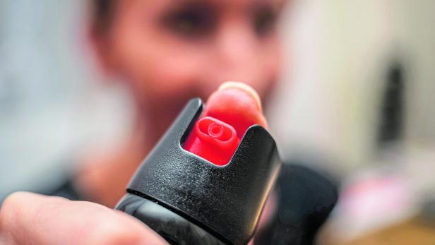 Close up of pepper spray in the girl's hand in the room