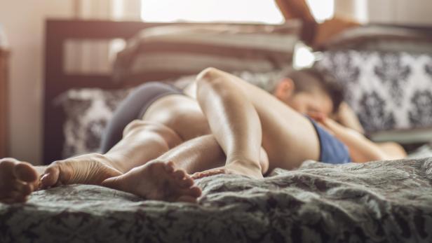 Ein lesbisches Paar kuschelt im Bett zu Hause.