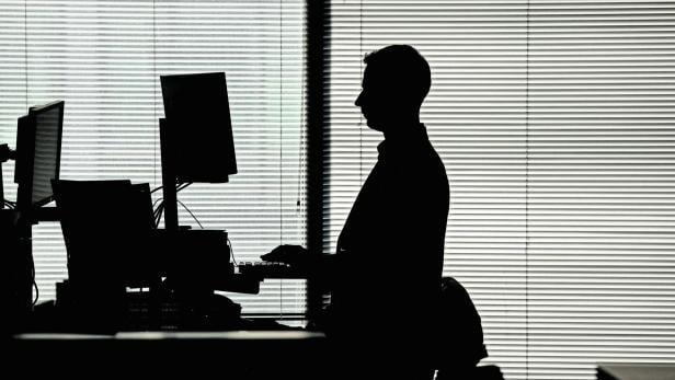 FILE PHOTO: A man works at a computer on a standing desk