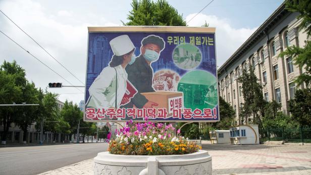 Ein Corona-Plakat in Pjöngjang zeigt Menschen mit Mundschutz