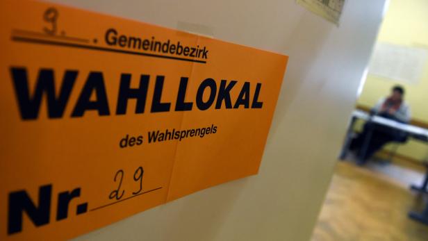 Ein Schild mit der Aufschrift „Wahllokal“ hängt an einer Wand.