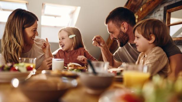 Familie isst gemeinsam am Tisch.