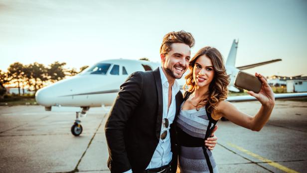 Wohlhabendes Paar vor einem  Privatflugzeugv.