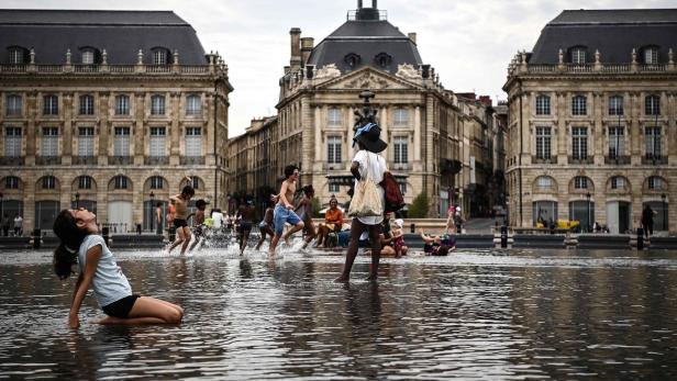 Kinder und Erwachsene planschen im Wasser in Bordeaux. 