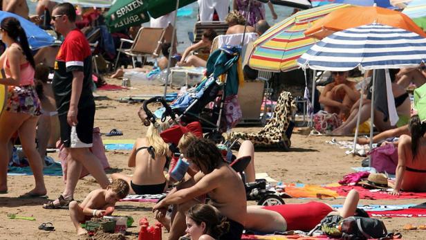 epa03339967 People sunbathe at a crowded beach in Salou, Tarragona, northeastern Spain, 04 August 2012, during the first weekend of the month of August when most of Spaniards take their holidays. EPA/JAUME SELLART