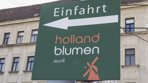 Ein grünes Schild mit der Aufschrift „Einfahrt Holland Blumen“ und einem Pfeil nach links.