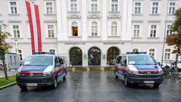 Zwei Polizeiwagen stehen vor dem Landesgericht und Bezirksgericht Linz.