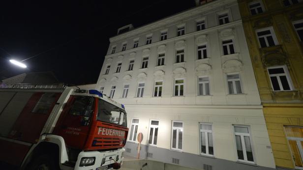 Ein Feuerwehrwagen der Stadt Wien steht vor einem Gebäude bei Nacht.