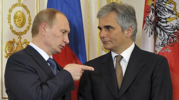 Wladimir Putin zeigt mit dem Finger auf Heinz Fischer vor den Flaggen Russlands und Österreichs.
