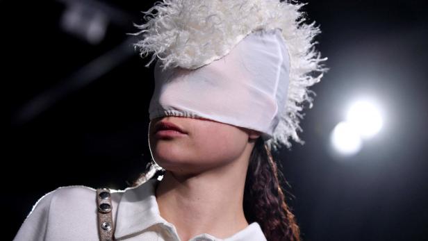 Ein Model trägt eine Kopfbedeckung, die die Augen verdeckt.