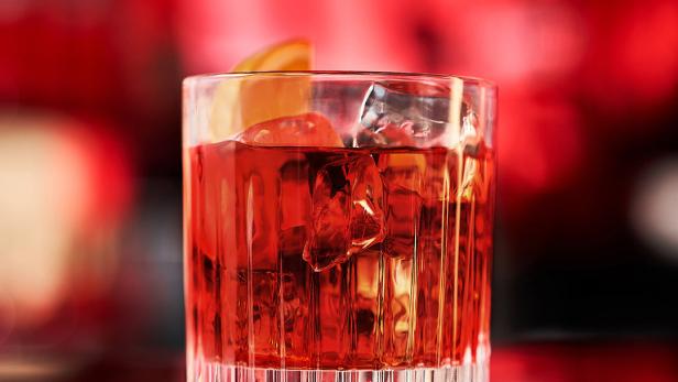Ein Glas Negroni mit Eiswürfeln und einer Orangenscheibe, beworben für die Campari Negroni Week.