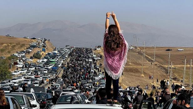 Das Bild, das am 26. Oktober 2022 auf Twitter (X) gepostet wurde, zeigt eine unverschleierte Frau auf einem Fahrzeug während sich Tausende auf den Weg nach Mahsa Aminis Heimatstadt machen.