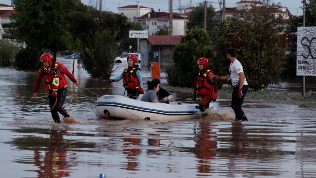 Rettungskräfte transportieren auf einem Schlauchboot eine Frau 