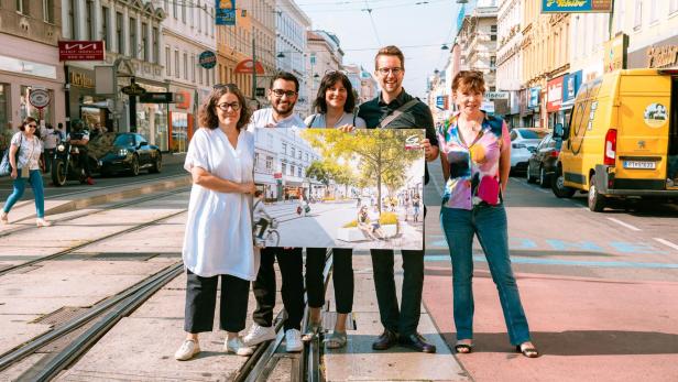 Fünf grüne Funktionärinnen und Funktionäre posieren mit einem Rendering auf der Wallensteinstraße
