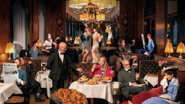 Eine lebhafte Szene in einem eleganten Restaurant mit Gästen in verschiedenen Kostümen und Posen.