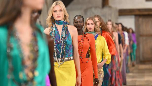 Models präsentieren farbenfrohe Mode auf einem Laufsteg.