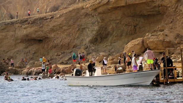 Touristen an einem Strand vor Dahab