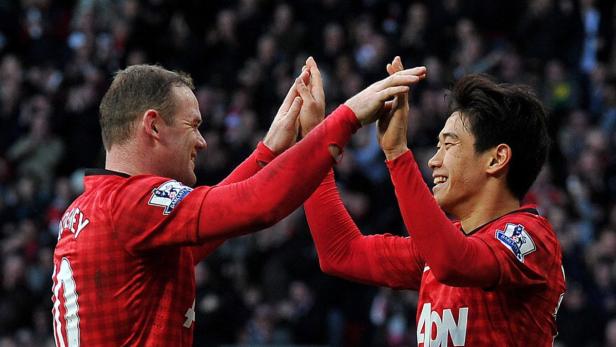 epa03607158 Shinji Kagawa (R) of Manchester United celebrates his goal which made the game 2-0 with teammate Wayne Rooney (L) during the English Premier League soccer match between Manchester United and Norwich City at Old Trafford Manchester, Britain, on 02 January 2013. EPA/DAVID RICHARDS DataCo terms and conditions apply. http//www.epa.eu/downloads/DataCo-TCs.pdf