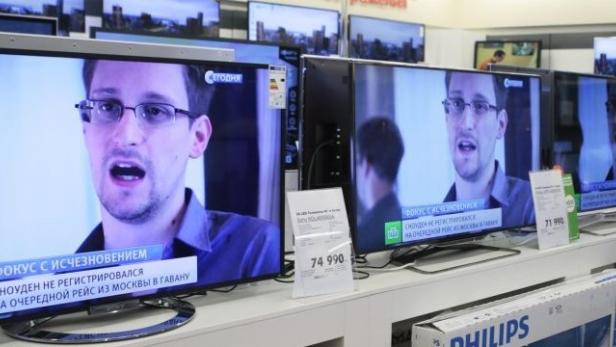 Television screens show former U.S. spy agency contractor Edward Snowden during a news bulletin at an electronics store in Moscow June 25, 2013. President Vladimir Putin confirmed on Tuesday Snowden, sought by the United States, was in the transit area of a Moscow airport but ruled out handing him over to Washington, dismissing U.S. criticisms as &quot;ravings and rubbish&quot;. REUTERS/Tatyana Makeyeva (RUSSIA - Tags: POLITICS SOCIETY)