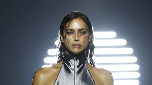 Irina Shayk trägt ein silbernes Kleid mit dem roten Schriftzug „So Wavy Lola“.