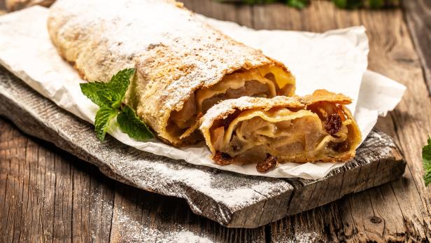Apfelstrudel auf einem Brett und mit Staubzucker überdeckt