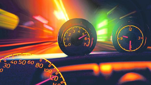 Das Armaturenbrett eines Autos zeigt Geschwindigkeit, Drehzahl und Uhrzeit während der Fahrt.