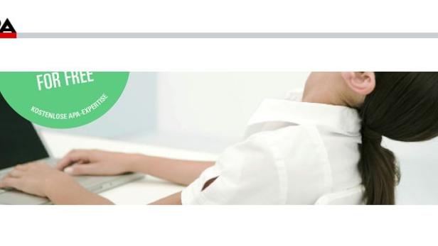 Eine Frau sitzt an einem Laptop und dehnt ihren Nacken.