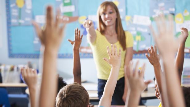 Elementary school class, raising hands