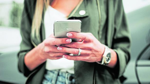 Woman hand typing in the mobile outside