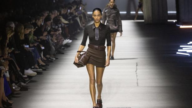 Eine Frau läuft auf einem Laufsteg während einer Modenschau.
