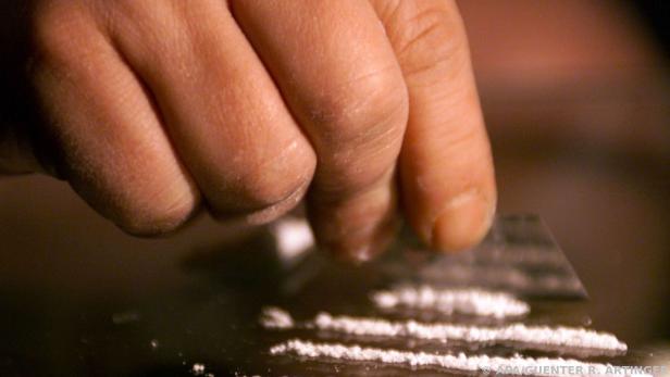 Kokain wird von einer Hand in Straßen gelegt. 