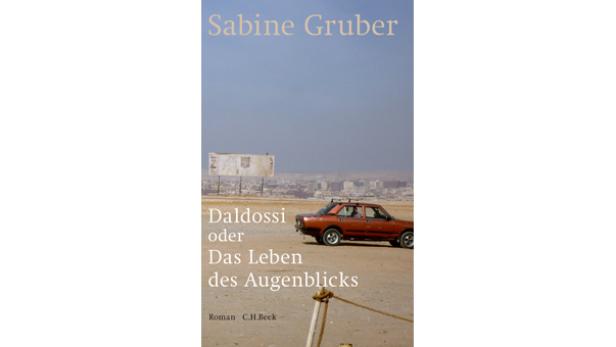 Das Cover des Buches „Daldossi oder Das Leben des Augenblicks“ von Sabine Gruber mit einem Auto in einer Wüstenlandschaft.