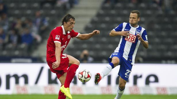 Zwei Fußballspieler kämpfen um den Ball während eines Spiels.