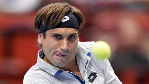 Ein Tennisspieler mit Stirnband leckt sich die Lippen, während er einen Ball schlägt.