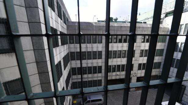 Blick durch ein Gitter auf ein mehrstöckiges Gebäude mit einem Innenhof.