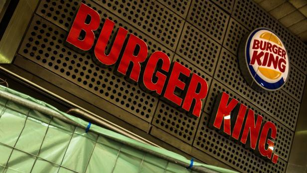 Das Logo von Burger King an einer Wand mit Lochmuster.