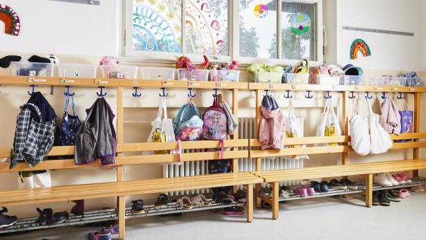 Eine Kindergartengarderobe mit Rucksäcken und Schuhen