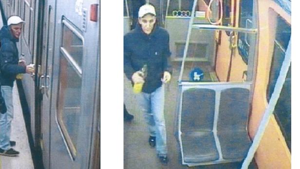 Ein Mann mit einer Flasche in der Hand steht in einem Zug.