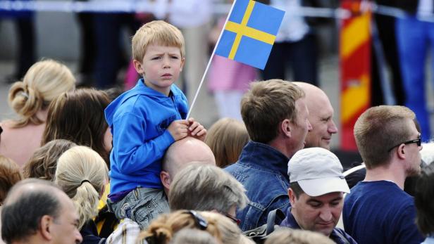 epa02211007 A boy with a Swedish flag is seen among people gathering outside the Royal Palace in Stockholm, Sweden, 19 June 2010, prior to the wedding of Swedish Crown Princess Victoria and Daniel Westling. The wedding ceremony will take place in Stockholm&#039;s Storkyrkan cathedral. EPA/CLAUDIO BRESCIANI ** SWEDEN OUT **