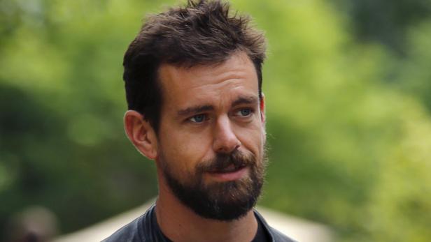 Ein Porträt von Jack Dorsey mit Bart vor einem grünen Hintergrund.
