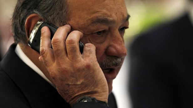 Ein Mann telefoniert mit einem älteren Mobiltelefon am Ohr.